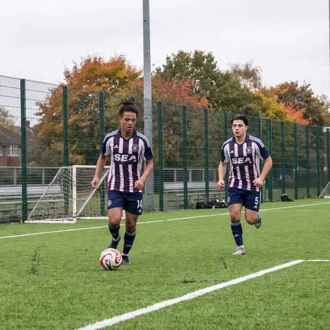 Gabriel Costa (#14) on the ball with Omar Khalil (#5) chasing in training on the turf